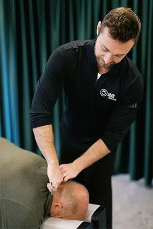 Chiropractic adjustment being performed on a patient's neck in a clinical treatment setting.